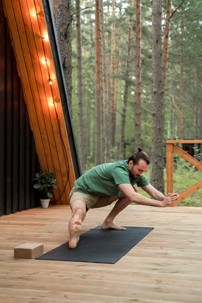 Porcelain Veneer Regrets: How to Heal and the 10 Pillars to Overcome It 3 A man performs yoga on a wooden deck surrounded by trees, embodying peaceful balance.